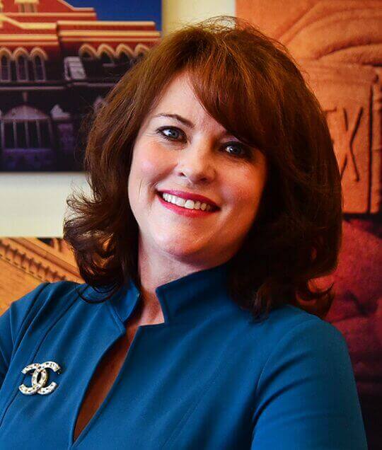 Professional woman smiling at Scale Community Events, showcasing empowered leadership and community engagement.