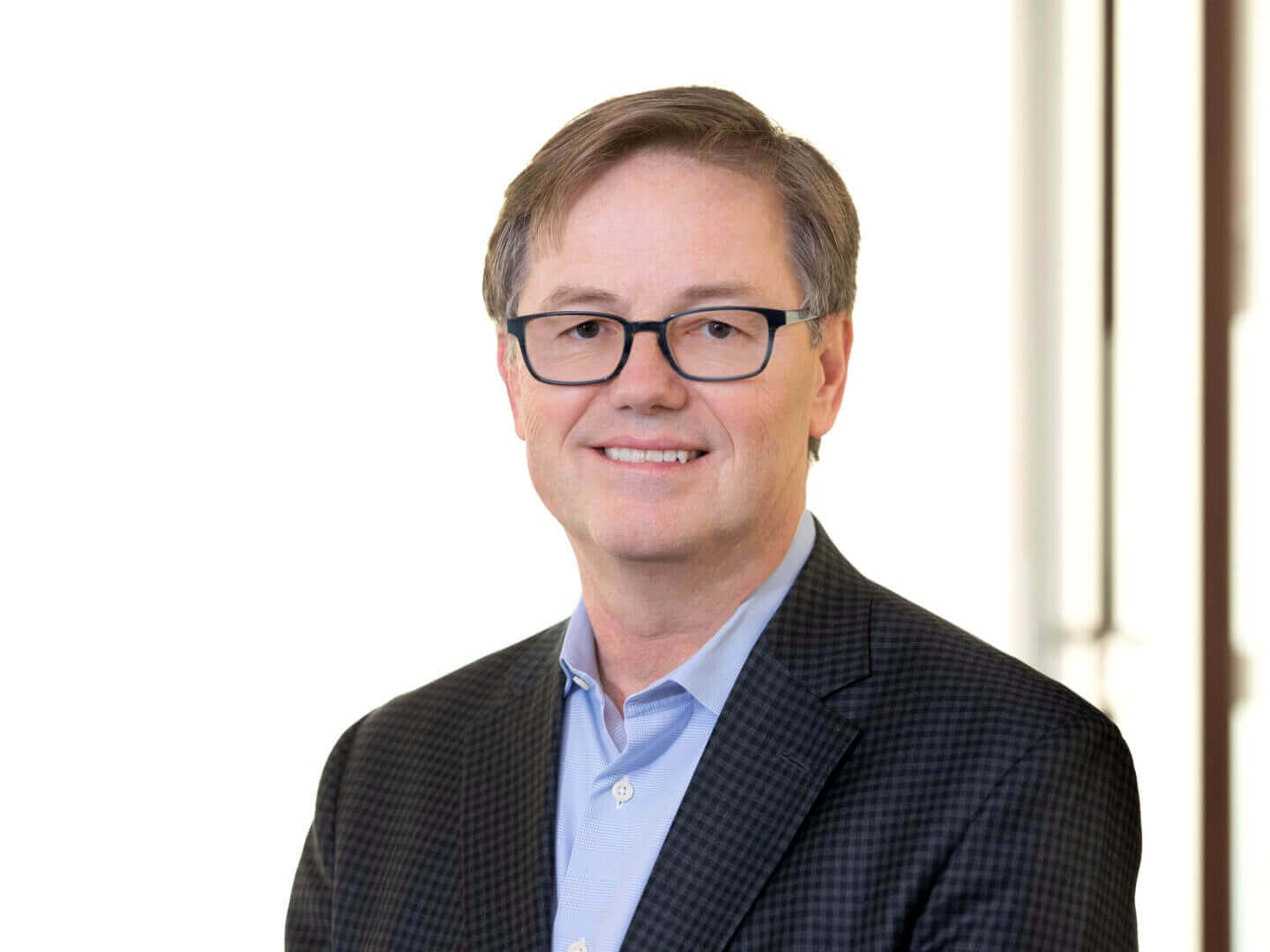 Person smiling in business attire, featured at Scale Community Events for professional networking.